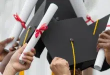 Graduation - Close up hands holding diplomas and caps