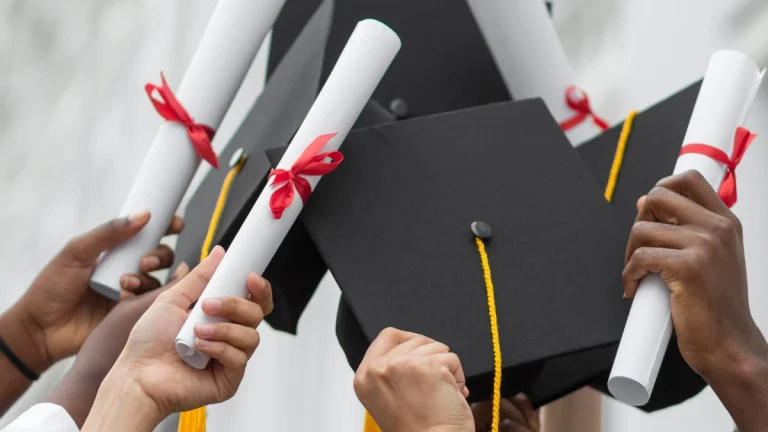 Graduation - Close up hands holding diplomas and caps