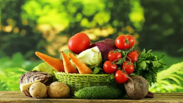 Fresh moringa leaves, garlic bulbs, ginger root, and turmeric in a basket