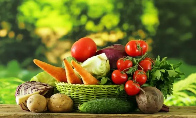 Fresh moringa leaves, garlic bulbs, ginger root, and turmeric in a basket