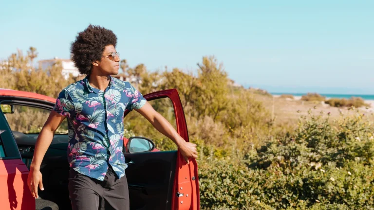 Young black man coming out of car on nature